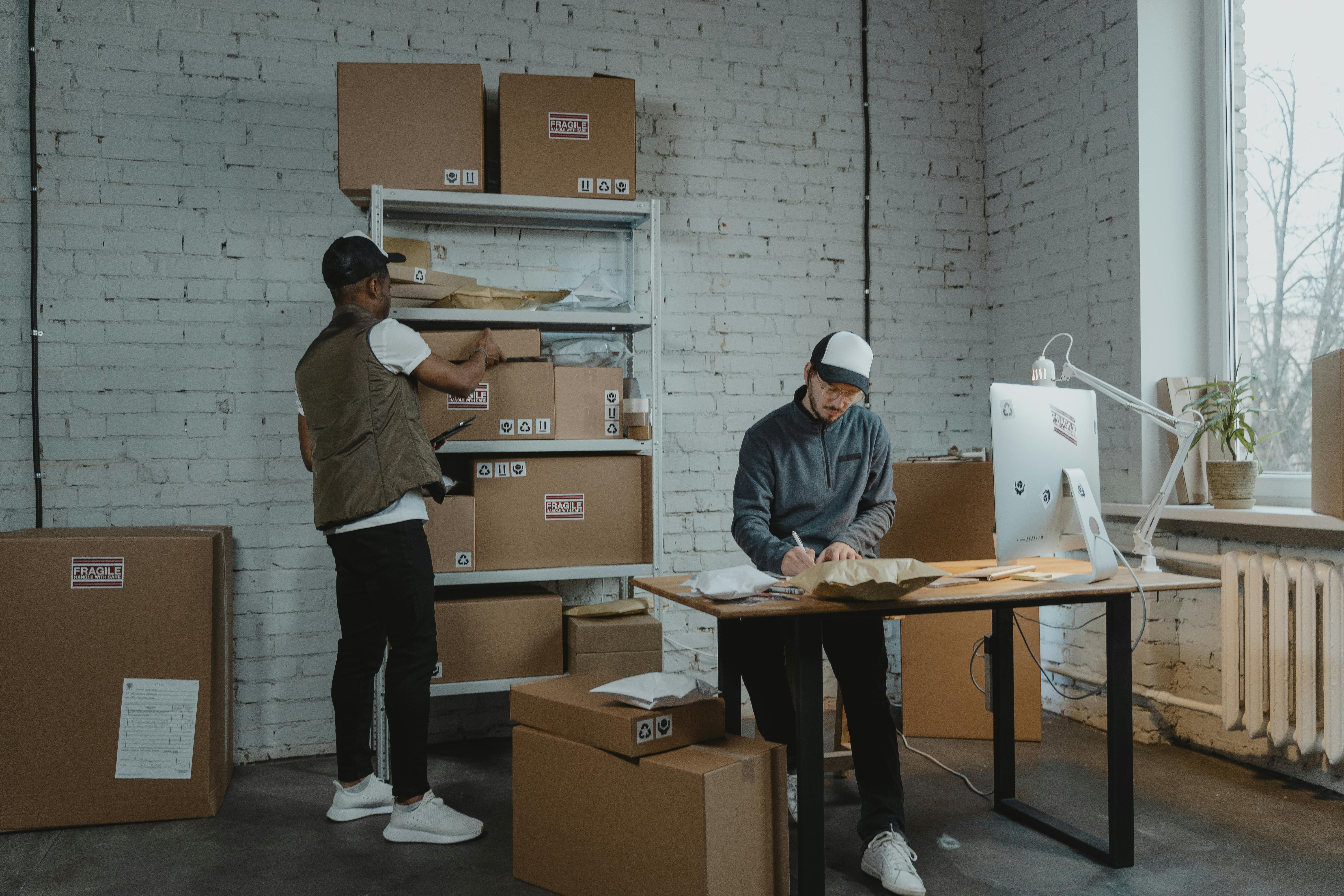 Warehouse workers packing parcels and checking outbound packages at a real packing station